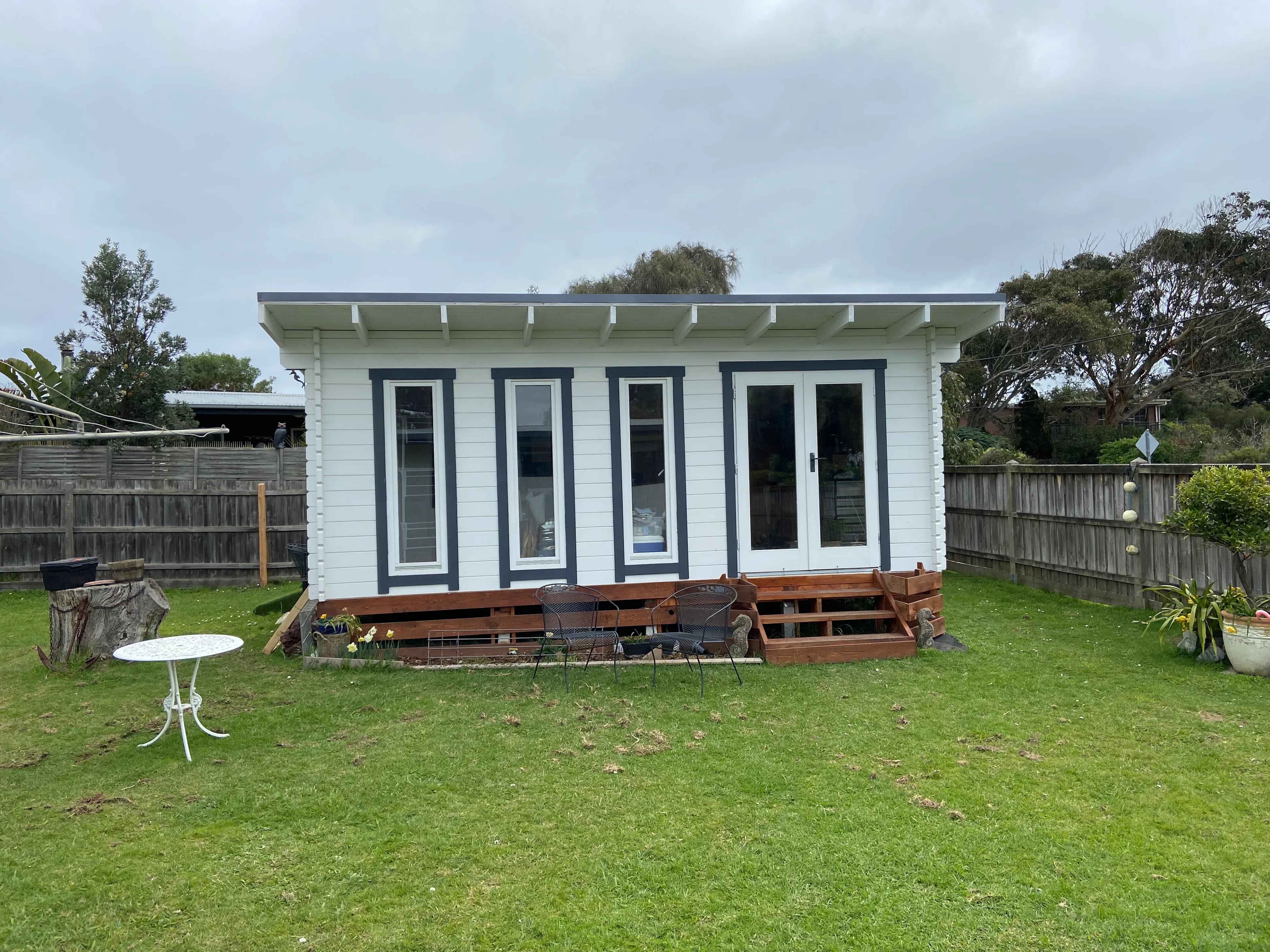 Front view of Karen's backyard studio with tall windows, double doors and timber steps